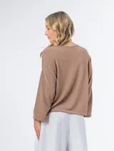 Sweater marrón de tejido de punto, con mangas 3/4 y cuello redondo.