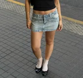 Minifalda de jean celeste con efecto lavado, tiro bajo y bolsillos delanteros y traseros.