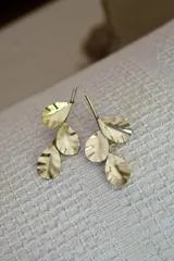 Aros colgantes dorados con forma de hojas.