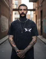 Remera negra con efecto lavado, corte clásico, cuello redondo y manga corta. Estampa en el pecho izquierdo con dos águilas enfrentadas y la leyenda "Pray I Mercy".