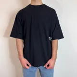Remera blanca de corte oversize con estampa de hongos y texto en la espalda.
