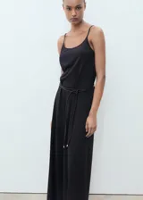 Mono largo negro de tirantes finos y corte recto, con cinturón fino trenzado.