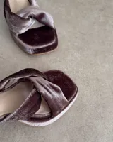 Sandalia de cuero vacuno color dorado, con plataforma y taco cuadrado. Presenta una tira delgada en el tobillo y detalle de nudo en la capellada.