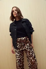 Pantalón ancho de tela liviana con estampado de hojas color crema sobre fondo azul. Tiene cintura elastizada con lazo ajustable.