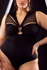 Body musculosa negro de lycra con transparencias de tul en escote y espalda, aro metálico en el centro del escote y broches en la entrepierna con refuerzo de algodón.