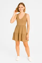 Vestido corto color marrón claro, de bretel ancho, cuello redondo y corte evase con falda de doble capa.