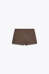 Shorts tiro bajo color negro con bolsillos delanteros. Cierre frontal con cremallera y ganchos metálicos.