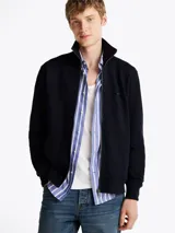 Buzo azul marino de felpa de algodón con cuello chimenea, cierre de cremallera, dos bolsillos delanteros estilo canguro, puños y bajo de punto canalé, logo de Tommy Hilfiger bordado en el pecho y detalles distintivos de la marca.