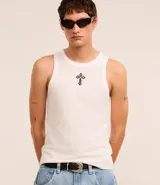 Musculosa blanca de algodón con cuello redondo, corte muscle y bordado de cruz texturizada en el pecho.