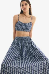 Pollera larga de algodón con estampado floral blanco sobre fondo azul, corte holgado, tiro alto y cintura elástica. Forrada.