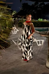 Vestido largo strapless con estampado abstracto en blanco y negro, con elástico en la parte trasera y bolsillos laterales. Incluye una pieza de tela roja para usar como chalina.