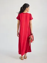 Vestido largo rojo de tejido de punto, con cuello en V y mangas cortas. Presenta costuras verticales a lo largo del vestido.