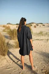 Camisa corta de jean celeste, de corte amplio, con cuello camisero, mangas largas abullonadas con puños elastizados, cierre frontal con botones y bolsillo plaqué en el pecho.