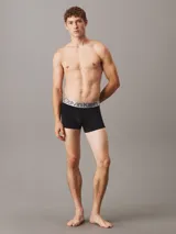 Pack de tres bóxers negros Calvin Klein con cintura elástica plateada y logo de la marca.