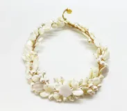 Collar corto hecho a mano con piezas de nácar blanco en forma de pétalos y perlas, engarzadas con hilo dorado. Cierre de mosquetón con cadena regulable.