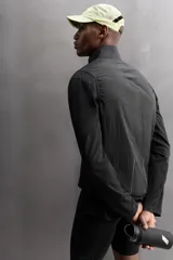 Chaleco negro de tejido técnico con estructura ripstop y ligero acolchado interior. Cuello alto ajustable con elástico, manga sisa, bolsillos de seguridad con cremallera en pecho y cadera, acabados con cinta elástica, cierre frontal con cremallera y logo estampado en el bajo.