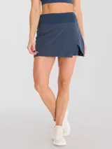 Falda deportiva negra con calza interior y bolsillo lateral. Diseño cruzado en la parte frontal.