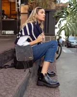 Botines negros de cuero con elástico lateral, detalle charol en el talón y suela track.