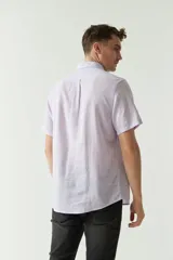 Camisa de manga corta color beige claro, confeccionada en lino y algodón, con cuello abotonado, bolsillo en el pecho y logo bordado. Corte semi slim.