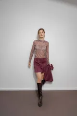 Minifalda color borgoña confeccionada en gamuza sintética con bordado de flechas en la parte delantera.