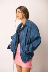 Campera de denim azul de corte oversize, con cuello, cierre frontal, bolsillos laterales amplios y ajuste en puños y bajo.