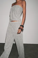 Pantalón gris jaspeado de tejido bouclé, tiro alto, cintura elástica y pierna ancha.