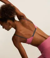 Top deportivo reversible en microfibra doble faz, color rosa con tiras grises. Tiene escote en V, breteles finos paralelos y copas removibles.