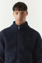 Campera de sherpa verde militar con cierre frontal y bolsillos laterales con cierre.