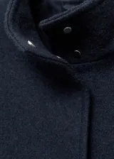 Chaqueta color crema de mezcla de lana con cuello alto y cierre de botones oculto.
