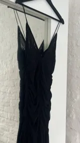 Vestido corto negro de microtul con escote en V y breteles finos.
