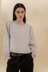 Blusa color beige de lino, con mangas largas abullonadas y puños con volados.