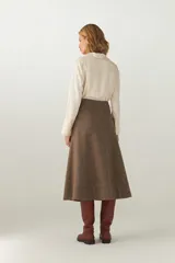 Falda midi evasé color beige, tejida en lana fina con detalle de pespuntes y cierre oculto.