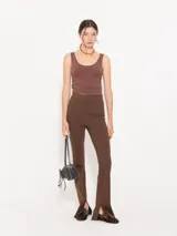 Pantalón negro de punto liso, con cintura elastizada y tajos laterales en el ruedo.