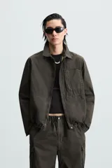 Cazadora color verde oscuro de corte relaxed fit, confeccionada en tejido técnico. Tiene cuello solapa, manga larga con puño abotonado, bolsillos plastrón en el delantero y bajo ajustable con elástico en los laterales. Presenta efecto lavado y cierre frontal con cremallera oculta por solapa con botones a presión.