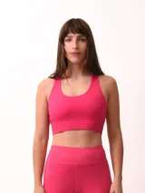 Top deportivo magenta con espalda cruzada y breteles anchos.