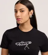 Remera negra de manga corta, corte ajustado al cuerpo, con cuello redondo y estampa frontal en blanco con la palabra "Anxiety" en tipografía cursiva y detalles gráficos.