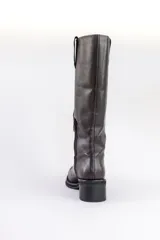 Bota alta de cuero color marrón oscuro, con taco bajo y caña recta.