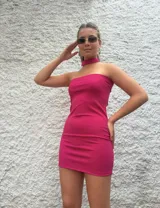 Minivestido fucsia strapless con choker al cuello. Puede usarse strapless o con escote halter.