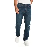 Jeans de hombre, corte slim, color azul oscuro con efecto lavado (dark stone). Presenta cierre de cremallera y botón, diseño de cinco bolsillos y parches con logo CAT en la cintura trasera y bolsillo trasero.