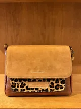 Cartera bandolera de cuero con estampado de piel de serpiente en tonos marrón y beige. Tiene correa larga ajustable y cierre con solapa.