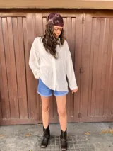 Camisa blanca de manga larga con detalle de bolitas en la tela.