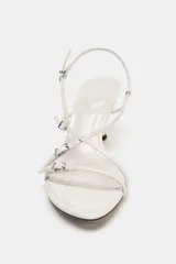 Sandalia de tacón color blanco con tiras finas cruzadas y detalles de hebillas metálicas.