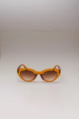 Lentes de sol ovalados con montura de acetato color naranja y lentes marrones degradados. Ofrecen protección UVA/UVB.