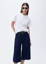 Camiseta blanca de algodón con cuello redondo, mangas cortas y diseño calado con bordado de lunares.