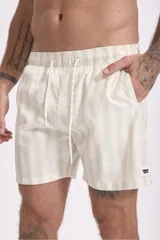 Short de baño color rosa con estampado de hojas y flores en tonos verdes, marrones y blancos.