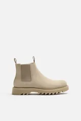 Bota Chelsea color beige de cuero, con elásticos laterales, tiradores delanteros y traseros, y suela track.