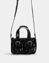 Cartera bowling negra de cuerina con manijas superiores, cierre superior y bolsillos frontales con hebillas. Incluye correa larga extraíble.