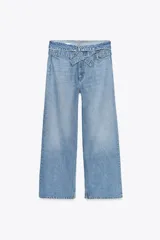 Pantalón de jean celeste de tiro alto, corte wide leg y largo hasta el tobillo. Incluye cinturón de la misma tela con trabillas y cierre frontal con cremallera, botón y gancho metálico.