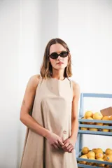 Vestido largo gris sin mangas, con escote redondo, bolsillos laterales y logo bordado en el frente.