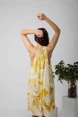 Vestido midi con estampado de hojas amarillas y marrones, corte suelto y cuello halter con lazo.